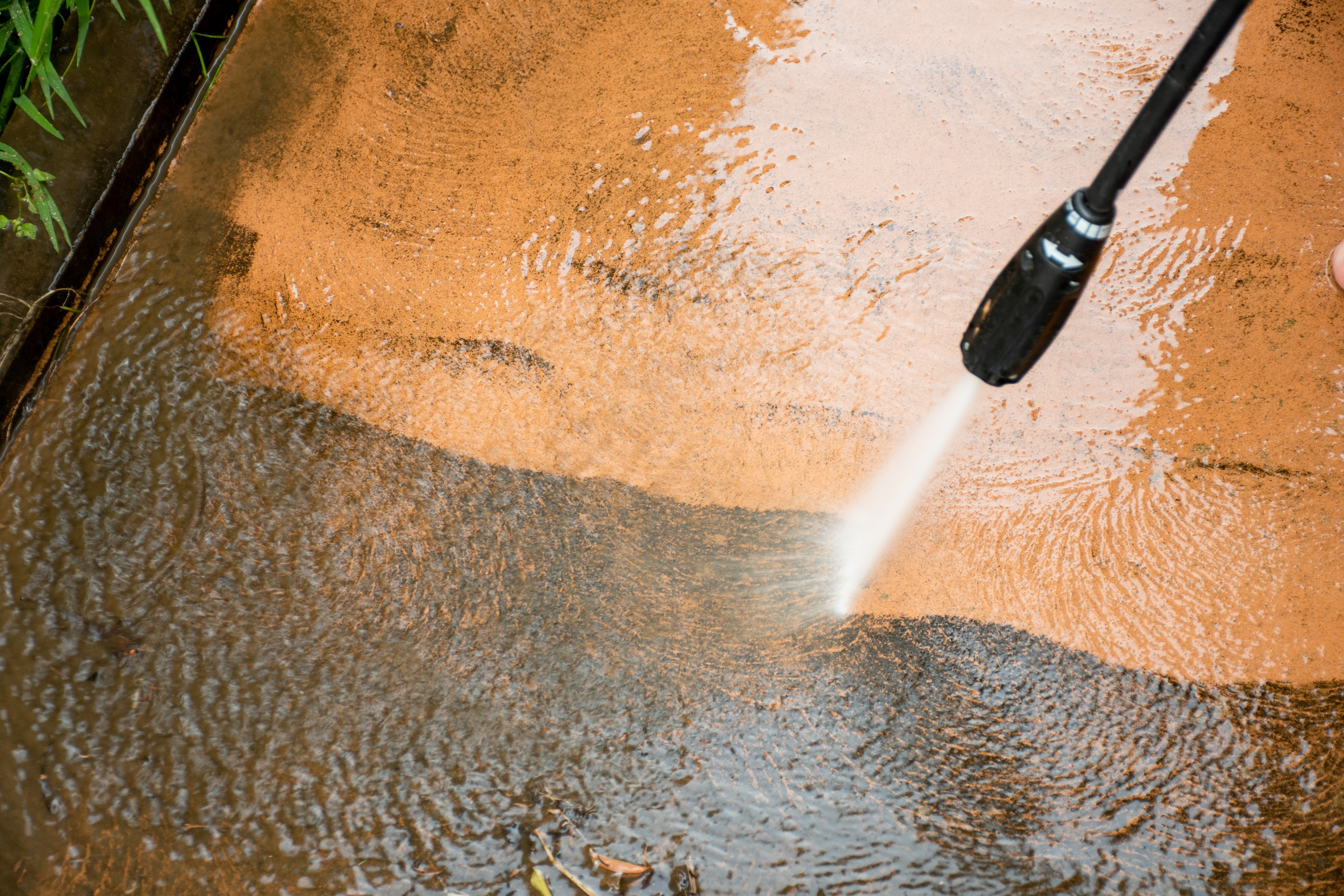 Pressure washing dirty patio concrete
