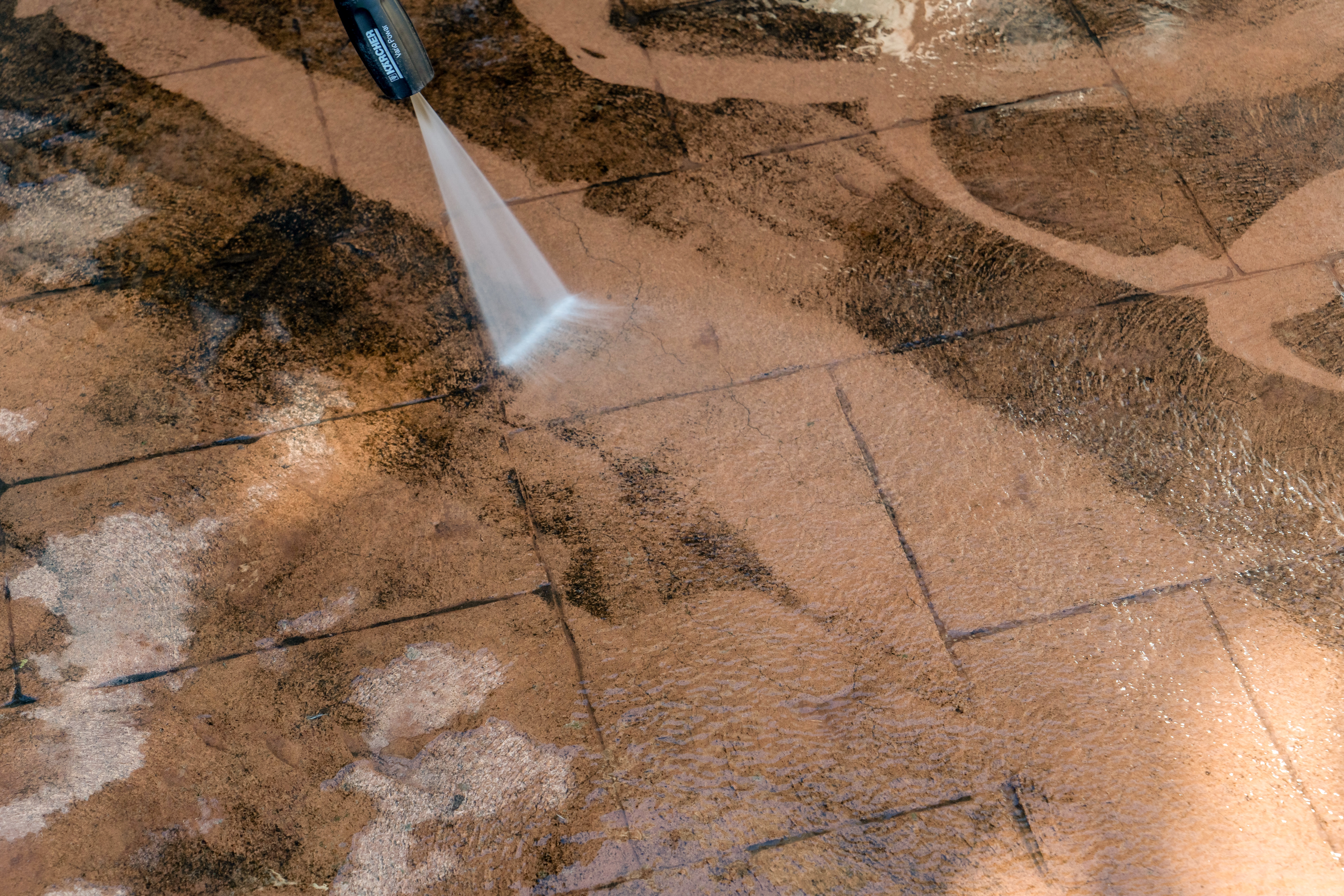 Pressure washing dirty patio stone tiles